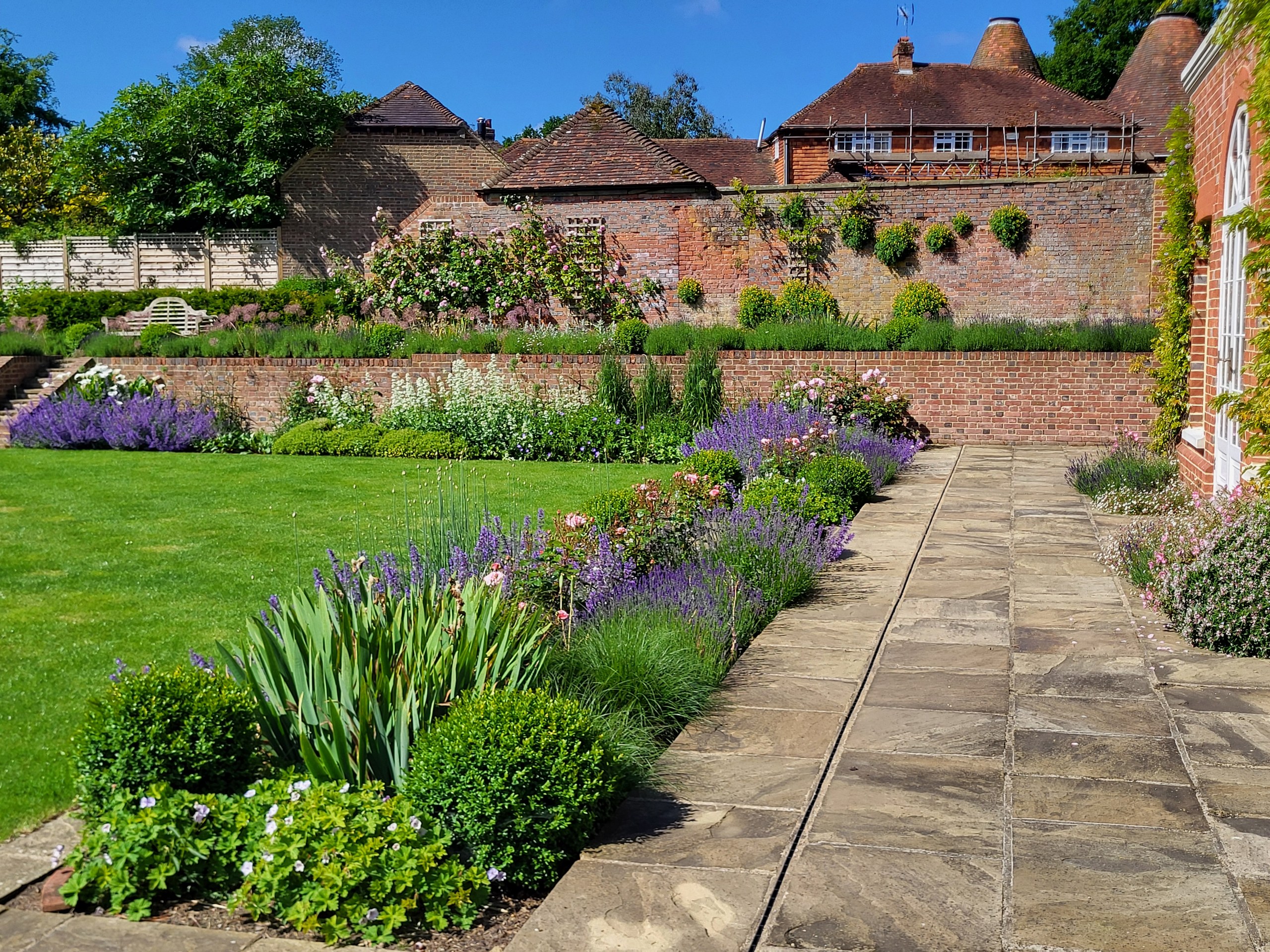 matfield-terraced-brick-garden-walls-wealden-country-landcraft Terraced brick garden walls and planted beds above a lawn and stone path in Matfield.